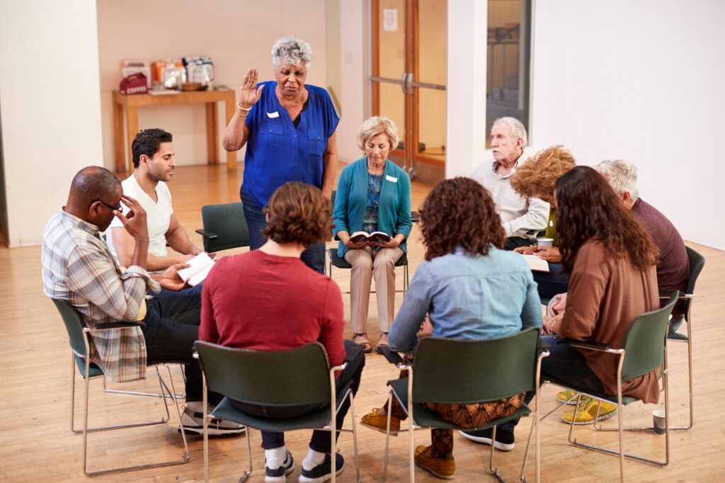 People Attending Bible Study Group Meeting In Community Center