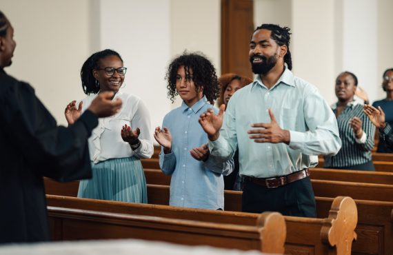 Group of people clapping and singing at a church service