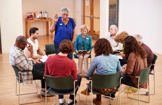 People Attending Bible Study Group Meeting In Community Center